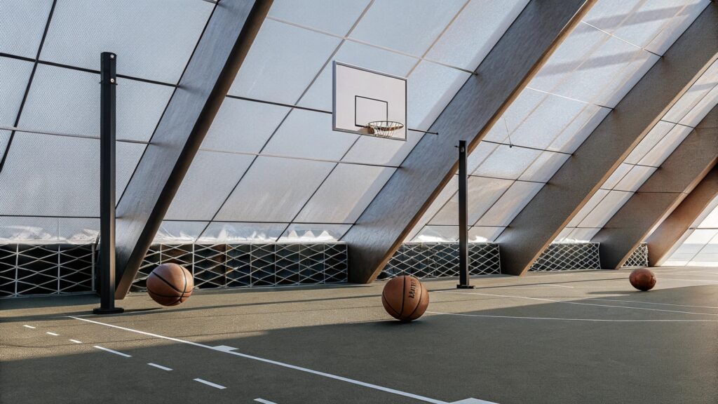 Indoor basketball court with modern glass roof and three basketballs.