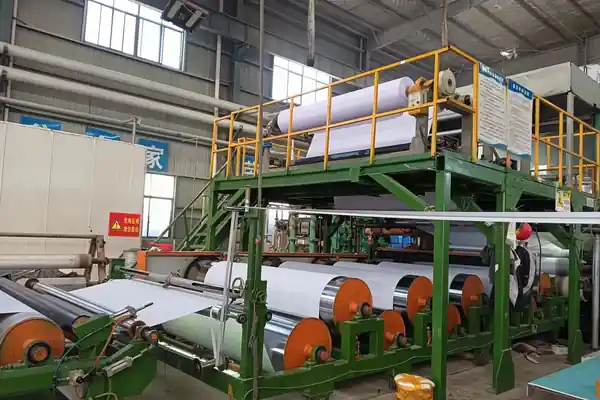 A large, organized warehouse filled with rolls of sports flooring